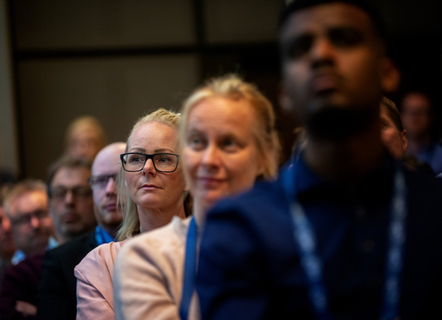 Bild på personer sittandes i ett led