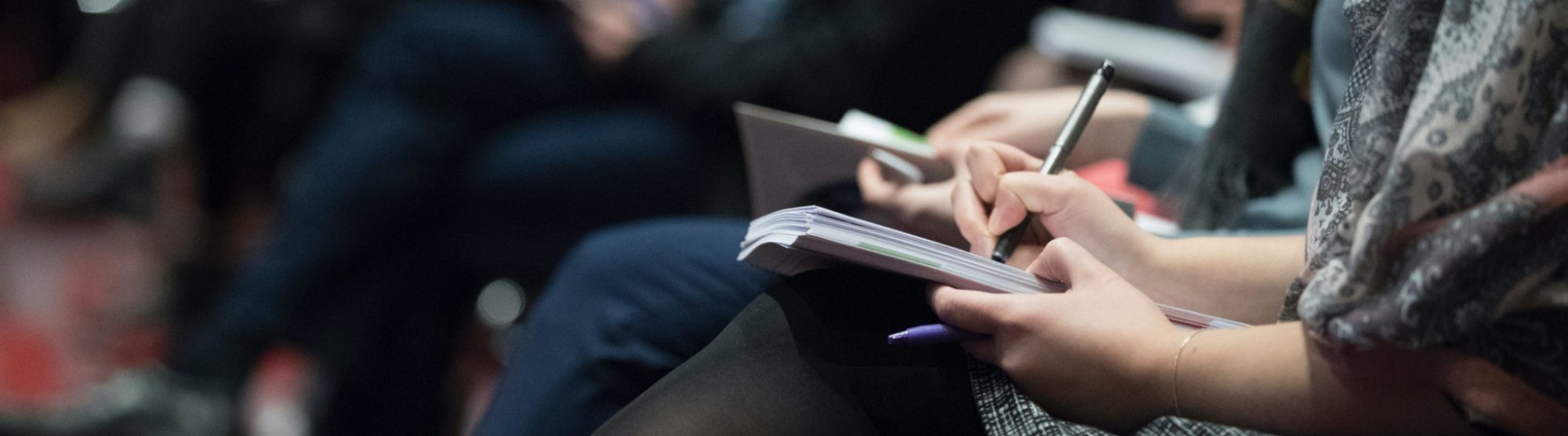 Fokus på en person som skriver i en anteckningsbok